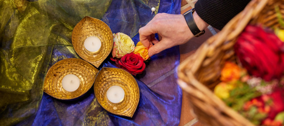 Dekoration von Blumen und Kerzenschalen auf Tülltüchern für eine Trauerzeremonie in Nahaufnahme