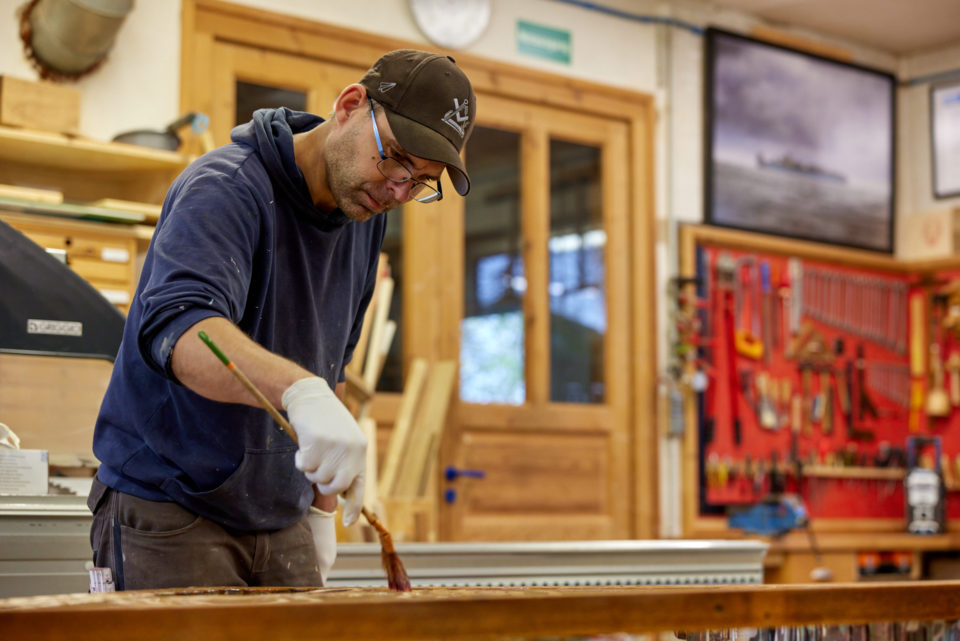 Jörg Klatt in der Tischlerwerkstatt bei der Oberflächenbehandlung eines Holzwerkstücks